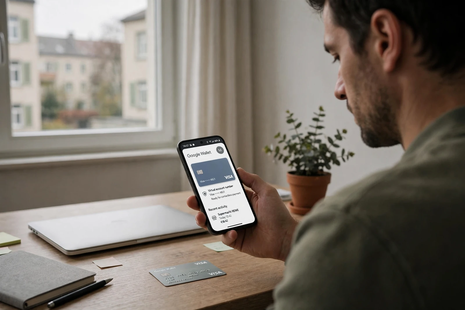 Person mit Smartphone und Google Pay am Schreibtisch in moderner Wohnung